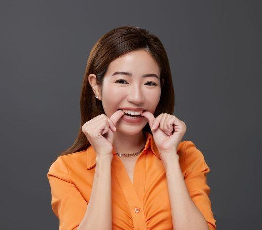 A woman putting on clear aligners.