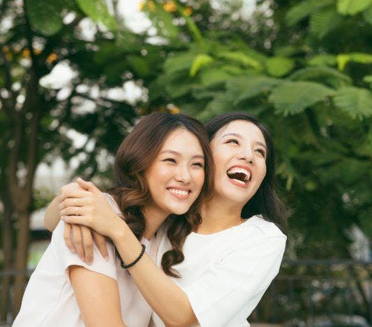 Two women smiling and laughing together.