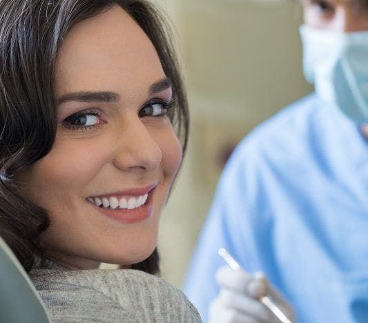 Young woman smiles with her teeth during a dental checkup.