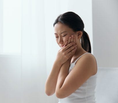 Woman holding her cheek in pain.