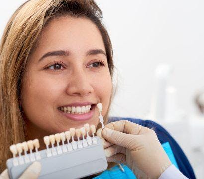 Woman getting her teeth measured for dental veneers.