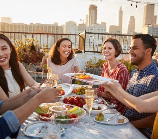 Making friends over food on a rooftop terrace, communication skills concept