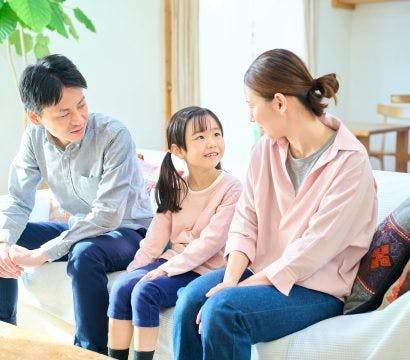 Asian parents talking to their daughter in the living room, parenting style concept.