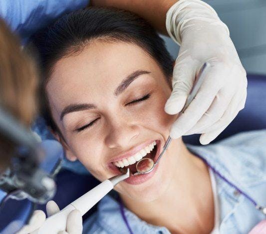 A woman getting her teeth checked by the dentist.