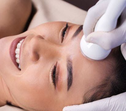 Top view of smiling woman getting a facial treatment.