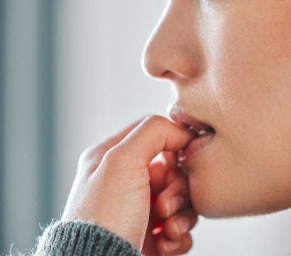 Side view of woman biting her nails.