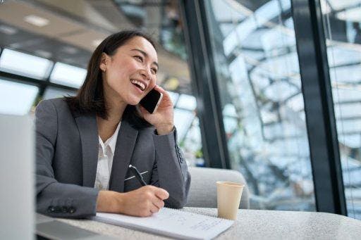 Woman happily talking on the phone at work.