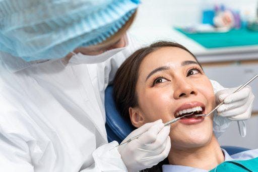Woman getting her teeth checked and cleaned by a dentist.