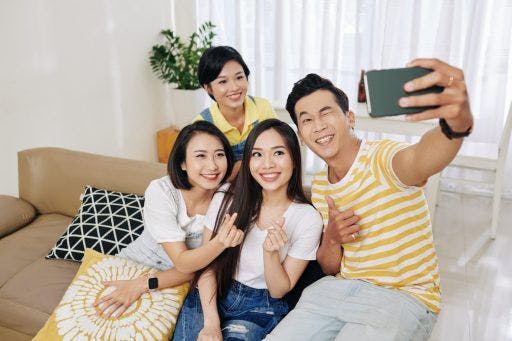 A group poses for a selfie on the couch. 