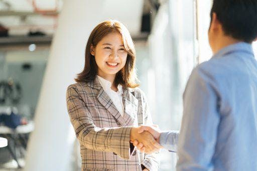 A businesswoman shaking hands with a colleague. 