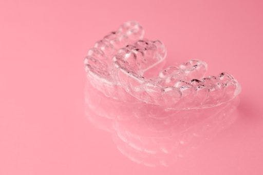 Aligners against pink background.