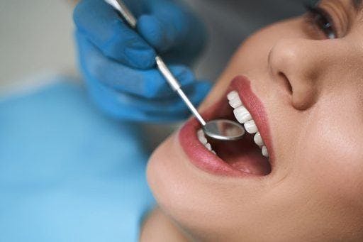 Close-up of a woman getting her teeth checked at the dentist. 