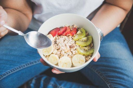 A bowl of oats, yogurt, and freshly cut fruits. 