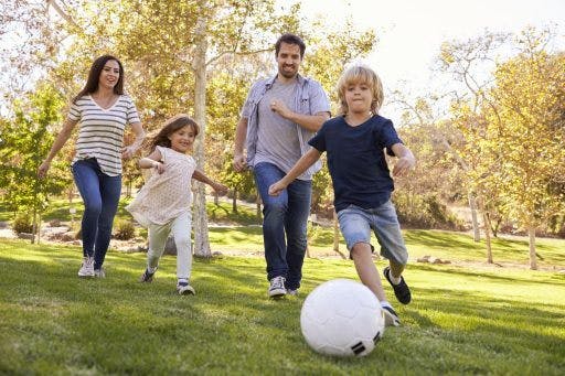 A family playing soccer outdoors.
