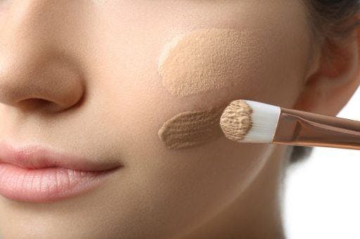 Close-up of light and dark foundation shades on a woman’s cheek. 