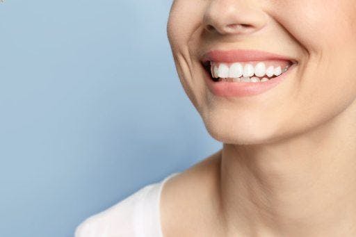 A woman with straight, white teeth smiling.