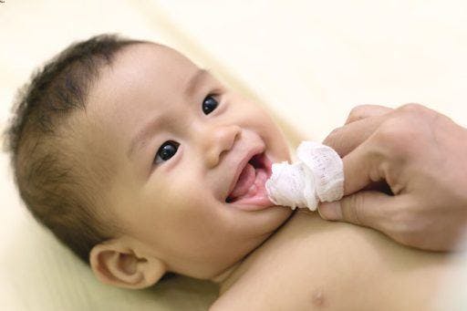 Mother cleans her baby’s mouth with boiled gauze.