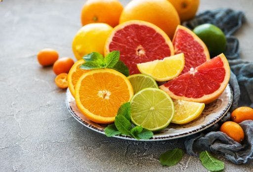 A plate of whole and sliced citrus fruits.