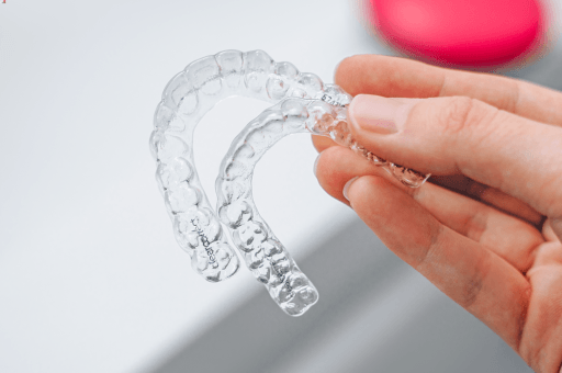 A hand holding a set of ClearCorrect aligner trays.