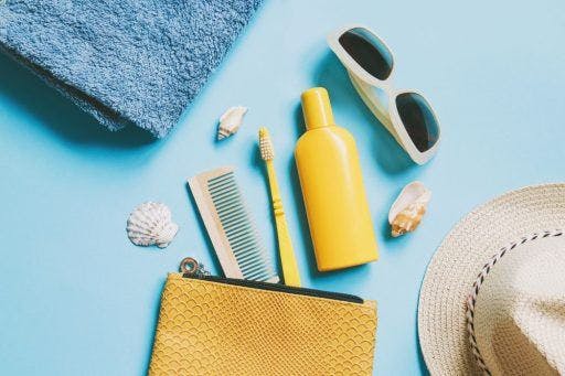 A zip pouch with travelling essentials, including a comb, toothbrush, and sunscreen.
