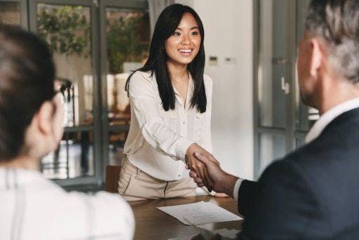 A woman shaking hands after a job interview.