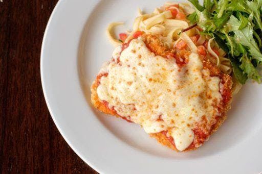 Chicken Parmigiana with noodles and a side salad. 