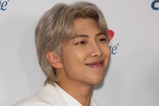 RM from BTS smiling against a white background.