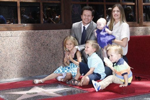 Mark Wahlberg and his family smiling on a red carpet.