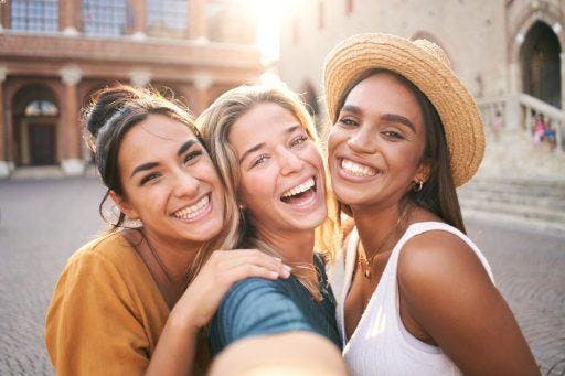 Young women taking a selfie and smiling into the camera of a smart phone. 