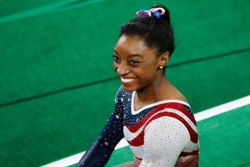 Gymnast Simone Biles smiling after winning a competition. 