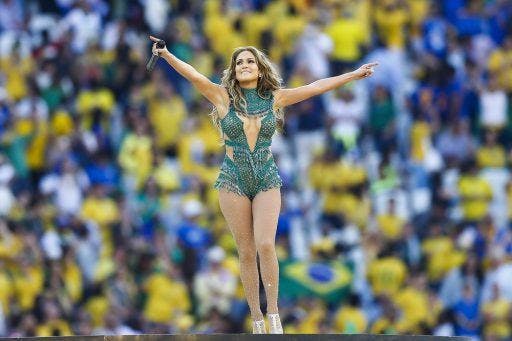 Jennifer Lopez in green performing for a large crowd.