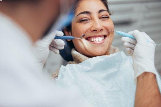 Smiling woman while a dentist examines her teeth.